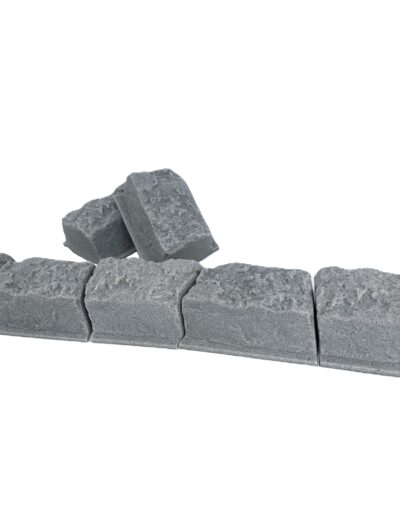 Row of gray concrete cinder blocks stacked on a white background.
