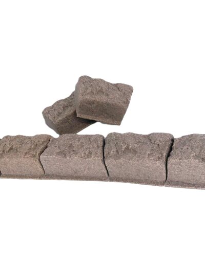 Row of brown concrete bricks forming a low wall, with a couple of loose bricks resting on top.
