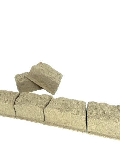 Row of gray concrete cinder blocks along the bottom edge on a white background, showing rough texture and slight diagonal arrangement.