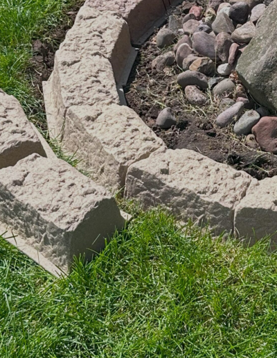 Light gray rectangular stones forming a short border along a grassy area.